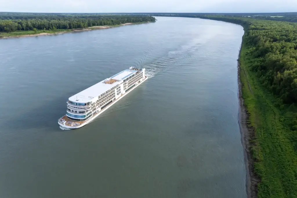 Photo of Mississippi River cruise for seniors vessel sailing past lush green riverbanks