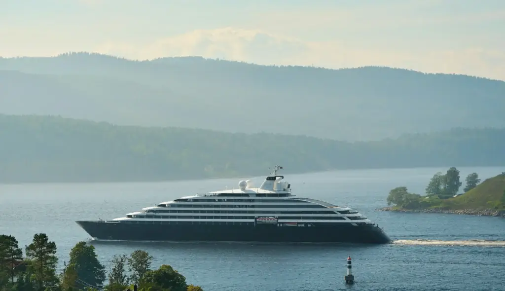 Photo-of-sleek-dark-luxury-cruise-ship-cruising-through-misty-fjord-landscape
