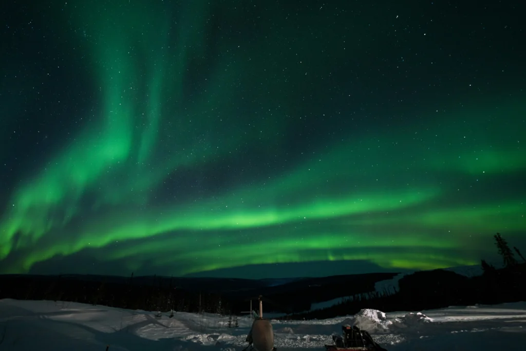 Photo bright green northern lights over snowy Alaska landscape at night