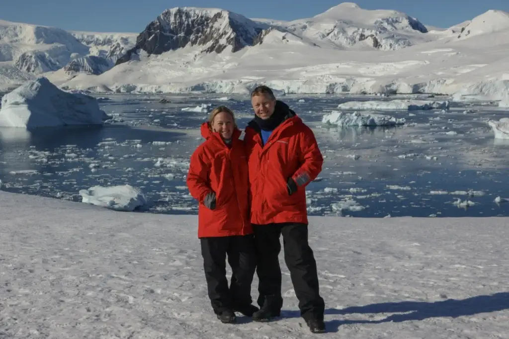 Photo of Yellow Umbrella Travel owners in red parkas standing on snow in Antarctica featured in how much does it cost to go to Antarctica