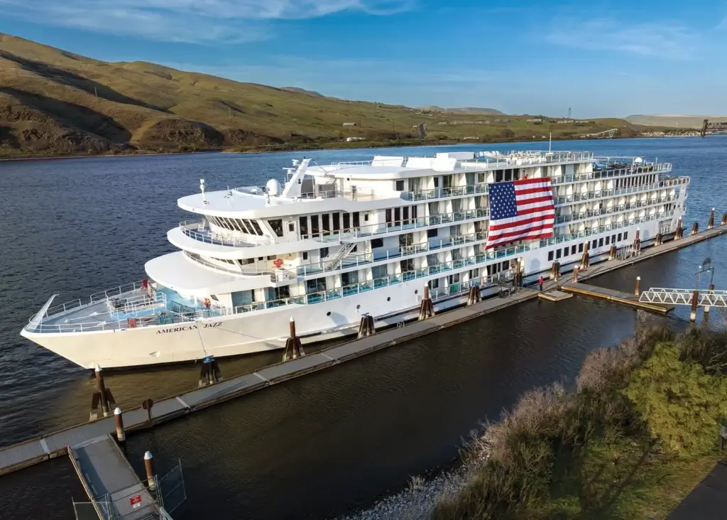 Photo of the American Cruise Lines Jazz cruise ship docked with large American flag