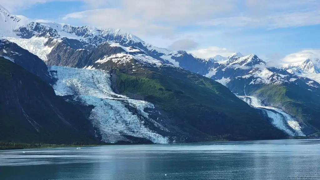 photo massive tidewater glacier flowing down snow capped alaskan mountains